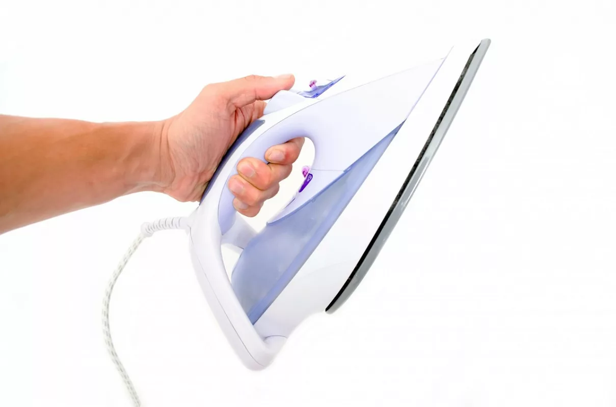 Using an iron to gently press the heat onto the clothtowel-covered sticker