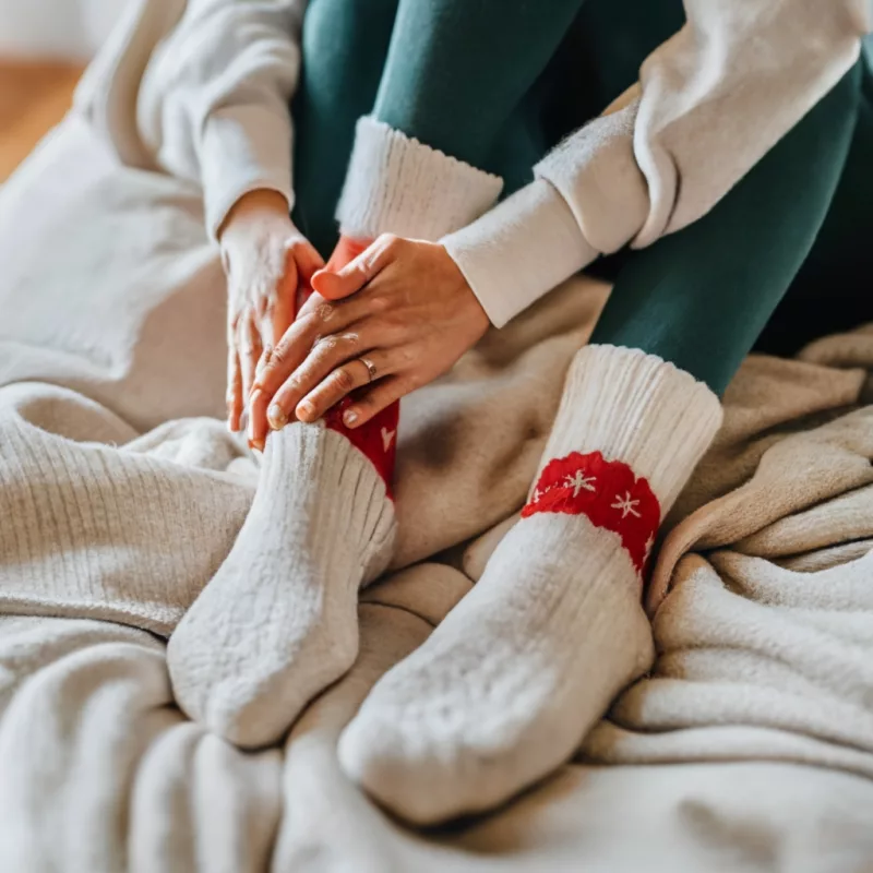 Warm holiday-patterned or colored socks as office Christmas party favors