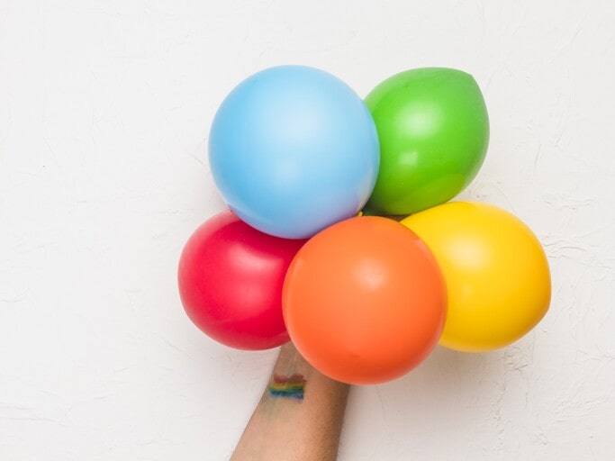 Use balloons in Cocomelon colors (green, yellow, red)