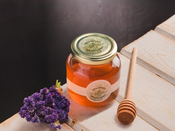 How to Make Honey Labels: A Practical Guide for Small Honey Brands 3 A circle label on the lid of a small honey jar